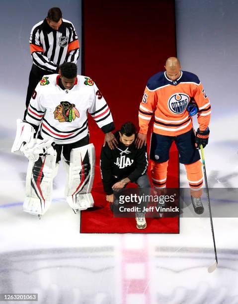 Malcolm Subban of the Chicago Blackhawks and Darnell Nurse of the Edmonton Oilers place their hands on Mathew Dumba of the Minnesota Wild during the...
