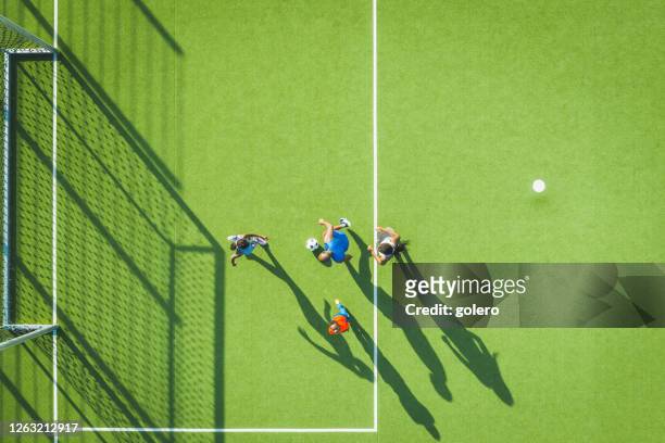 familie spielt gemeinsam fußball auf grünem fußballplatz - aerial football stock-fotos und bilder
