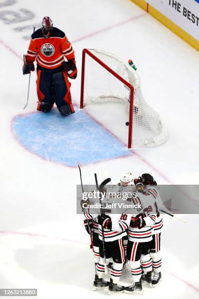 Jonathan Toews of the Chicago Blackhawks is congratulated by teammates after he scored his second goal of the game as Mike Smith of the Edmonton...