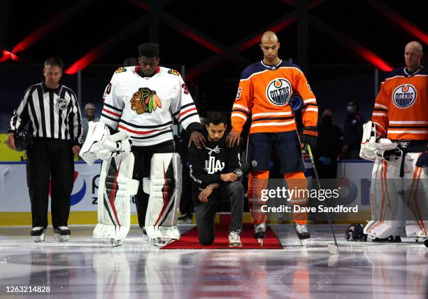 Malcolm Subban of the Chicago Blackhawks and Darnell Nurse of the Edmonton Oilers place their hands on Mathew Dumba of the Minnesota Wild during the...