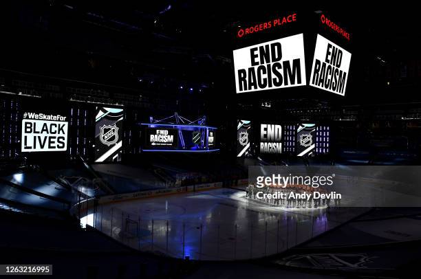 End Racism signs are seen as Mathew Dumba of the Minnesota Wild speaks at center ice before Game One of the Western Conference Qualification Round...