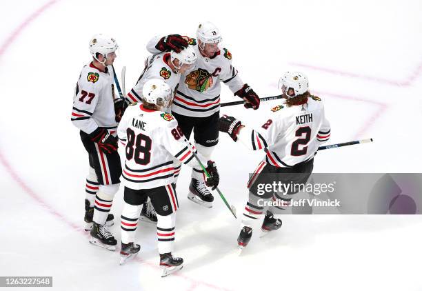 Dominik Kubalik of the Chicago Blackhawks is congratulated by teammates Jonathan Toews, Patrick Kane, Kirby Dach and Duncan Keith after Kubalik...