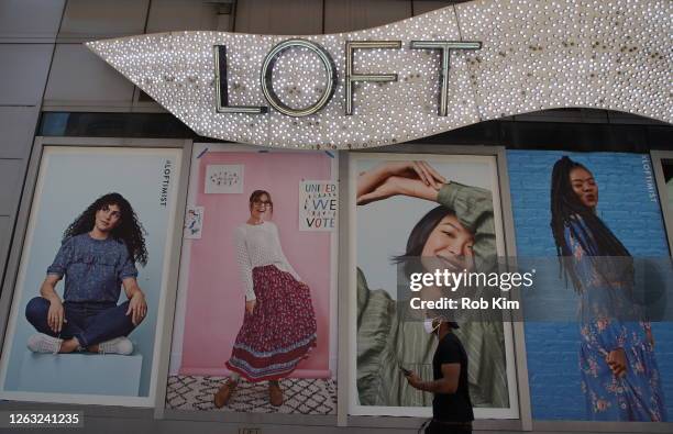 Person wearing a protective face mask walks by a Ann Taylor LOFT retail store in Times Square during Phase 4 of re-opening following restrictions...