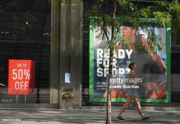 Person walks by the Adidas store during Phase 4 of re-opening following restrictions imposed to curb the coronavirus pandemic on August 1, 2020 in...