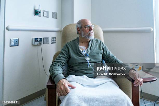 senior adult man cancer outpatient during chemotherapy iv infusion - paciencia fotografías e imágenes de stock