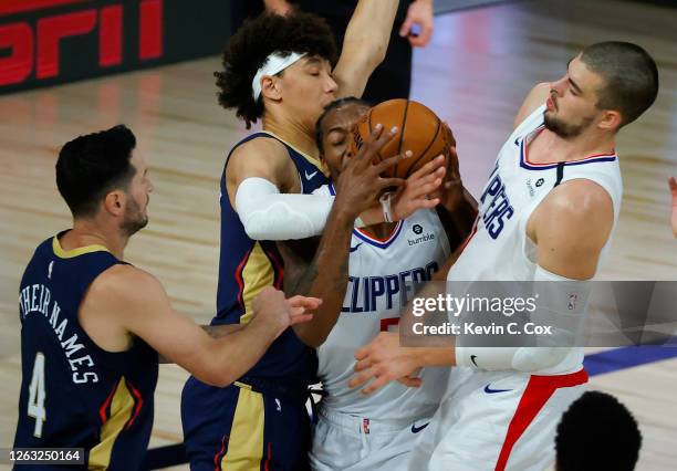 Kawhi Leonard of the LA Clippers tangles with Frank Jackson of the New Orleans Pelicans as JJ Redick of the New Orleans Pelicans and Ivica Zubac of...