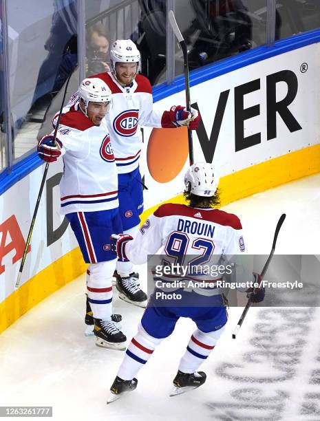 Nick Suzuki of the Montreal Canadiens is congratulated by teammates Jonathan Drouin and Joel Armia after he scored an unassisted goal in the second...