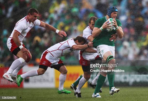 Jamie Heaslip of Ireland is tackled by Andrey Kuzin, Alexander Yanyushkin and Vladimir Ostroushko during the IRB 2011 Rugby World Cup Pool C match...