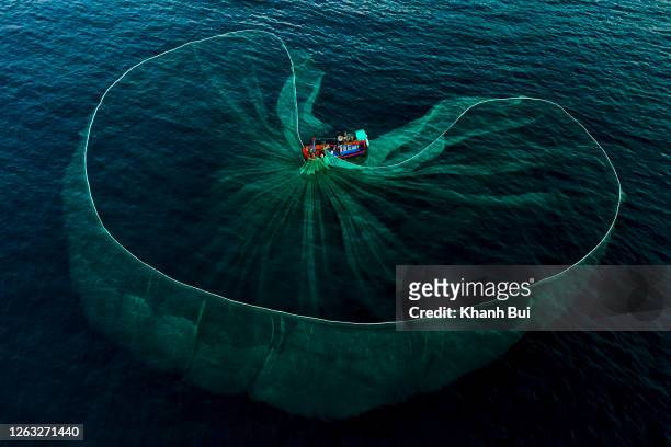 art of fishing net drop on the sea with hard working of the tradition fishermen - trawler stockfoto's en -beelden