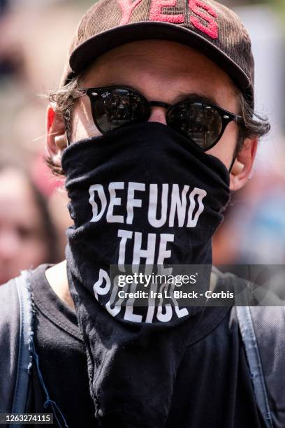 Protester wears a mask that says, "Defund the Police" at the Black Lives Matter protest in Bayside, Queens. This peaceful protest was a March against...