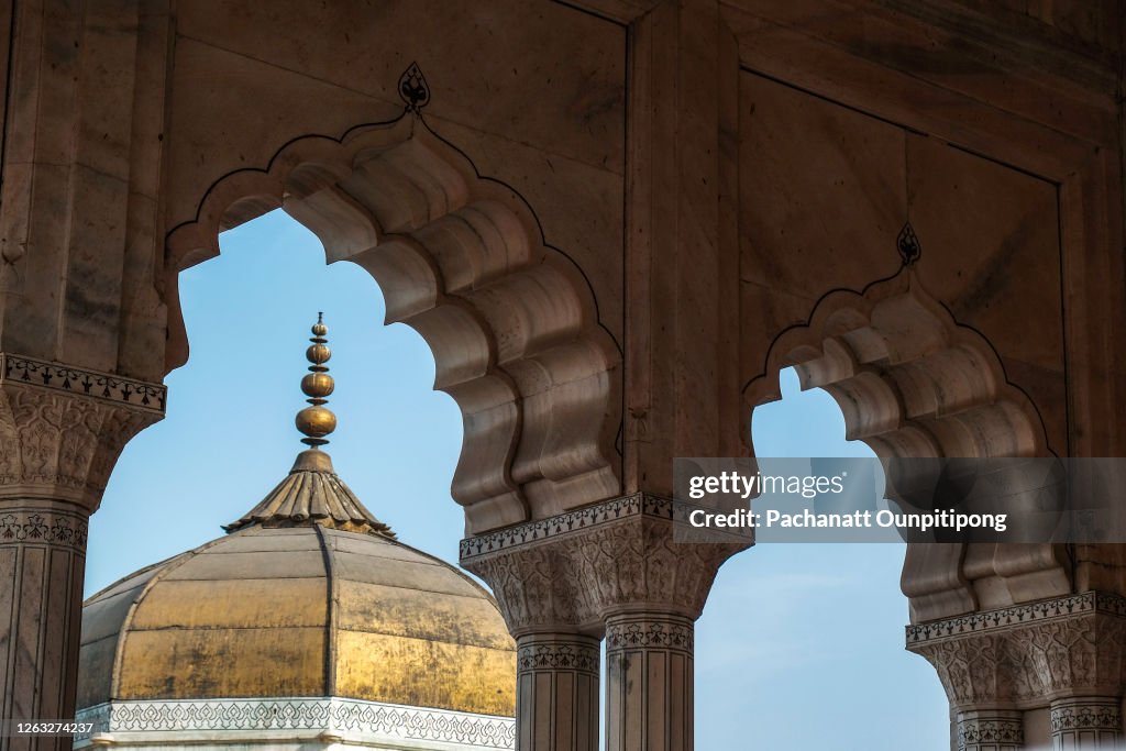 A part of golden roof of Musamman Burj look through door frames with clear blue sky at Agra Fort, India