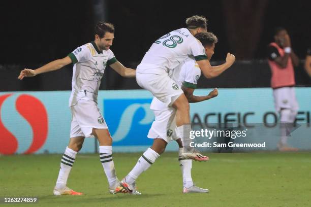 Andy Polo of Portland Timbers celebrates with teammates Bonilla and Valeri after scoring the third goal of their team during a quarter final match of...