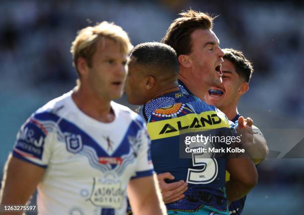 Clinton Gutherson of the Eels celebrates his try with Michael Jennings and Dylan Brown of the during the round 12 NRL match between the Canterbury...