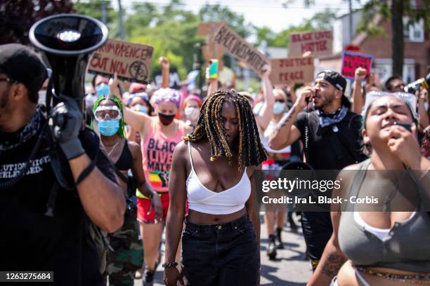 Kiara Williams, an organization leader of Warriors in the Garden walks between other protesters that are using megaphones and microphones to lead the...