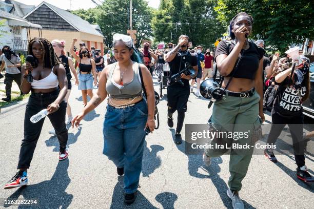 Members of the Warriors in the Garden lead a crowd of protesters as they walk through neighborhoods at the Black Lives Matter protest in Bayside,...