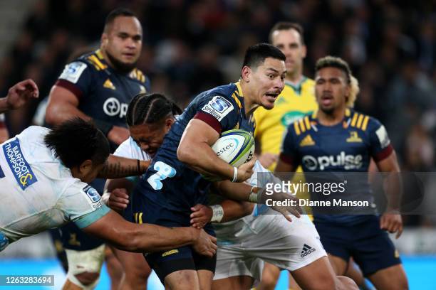 Patelesio Tomkinson of the Highlanders is tackled during the round 8 Super Rugby Aotearoa match between the Highlanders and the Blues at Forsyth Barr...