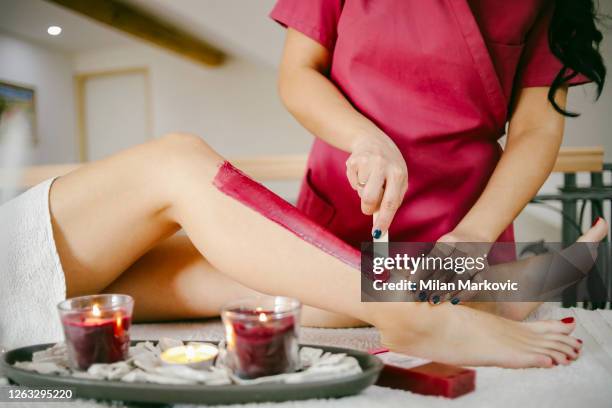 a beautician waxes a woman's leg in a salon - beautiful female legs - preparing bodies for the summer - female body waxing stock pictures, royalty-free photos & images