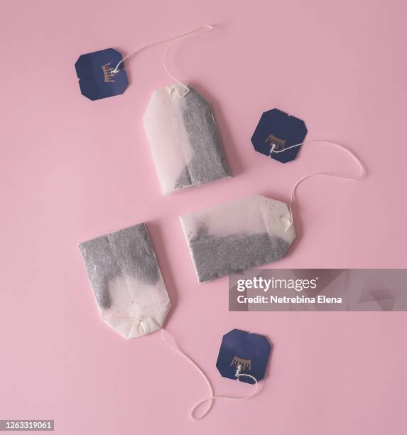 three bags of black tea on a pink background. - ティーバッグ ストックフォトと画像