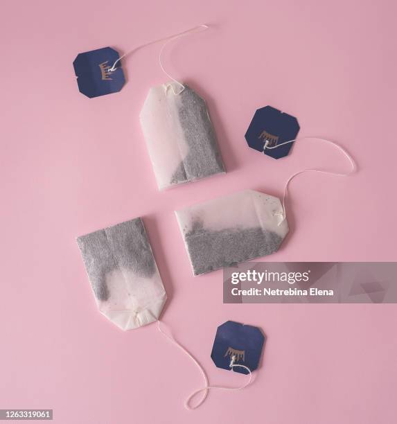 three bags of black tea on a pink background. - tea bag stock pictures, royalty-free photos & images