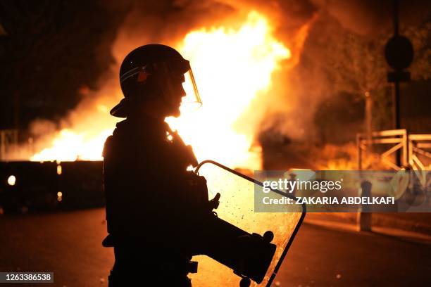 Firefighter looks on as vehicles burn following riots in Nanterre, west of Paris, on June 28 a day after a 17-year-old boy was shot in the chest by...