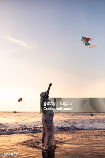 asian pregnant women playing kite on the beach - indonesian kite stock pictures, royalty-free photos & images
