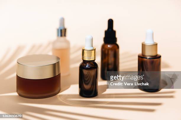 spa cosmetics in brown glass bottles on broun background. copy space for text. beauty blogger, salon therapy, branding mockup, minimalism concept. various facial massage oils for spa treatment. - amenities stock-fotos und bilder