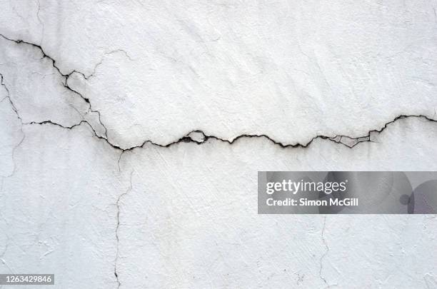 mouldy and cracked whitewashed wall - zerbrochen stock-fotos und bilder