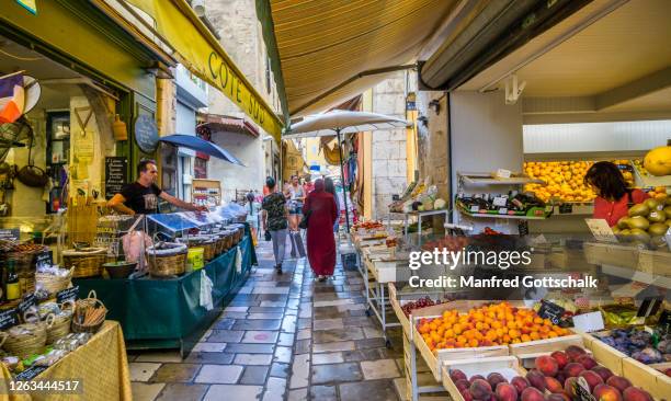 alleyway with market stalls in the medieval old town of the ancient mediterranean city of hyères, provence-alpes-côte d'azur, france, july 12, 2018 - region provence alpes côte dazur stock-fotos und bilder