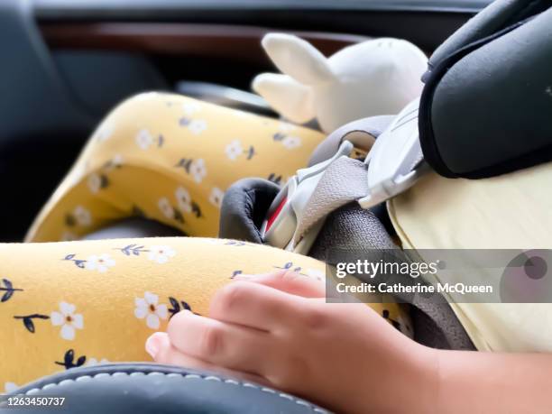 mixed-race toddler female clutches a toy rabbit while sleeping in car seat - baby accessories the dummy stock pictures, royalty-free photos & images