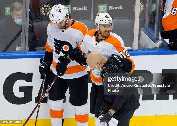 Michael Raffl of the Philadelphia Flyers has a few words as he is walked off the ice after a hit by Jeremy Lauzon of the Boston Bruins during Game...