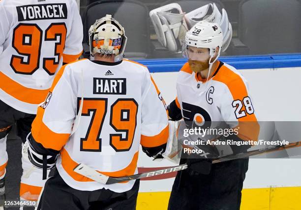 Claude Giroux of the Philadelphia Flyers congratulates Carter Hart of the Philadelphia Flyers after the 4-1 win over the Boston Bruins during Game...