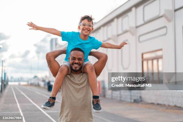 boy flying on father's shoulder - flying dad son stock pictures, royalty-free photos & images