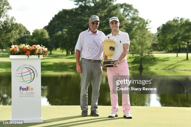 Justin Thomas of the United States poses with the trophy and his father, Mike Thomas, after winning the World Golf Championship-FedEx St Jude...