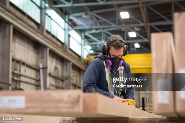 de arbeider die van de fabriek beschermend gezichtsmasker het schuren van hout draagt. - face mask protective workwear stockfoto's en -beelden