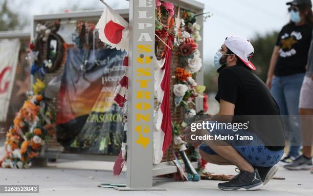 People view a temporary memorial in Ponder Park honoring victims of the Walmart shooting which left 23 people dead in a racist attack targeting...