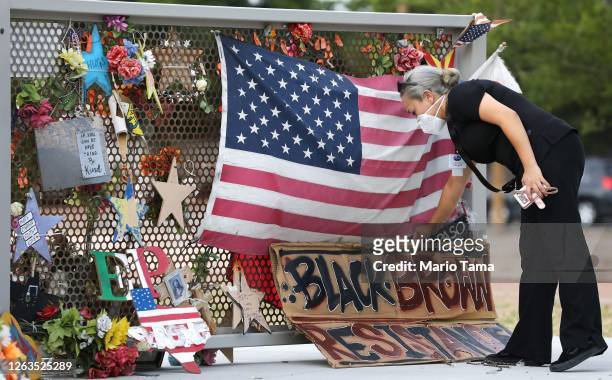 Woman places a sign at a temporary memorial in Ponder Park honoring victims of the Walmart shooting which left 23 people dead in a racist attack...