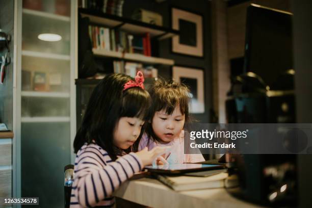 thai adorable sisters playing game at the working area, quarantine in bangkok - children only stock pictures, royalty-free photos & images