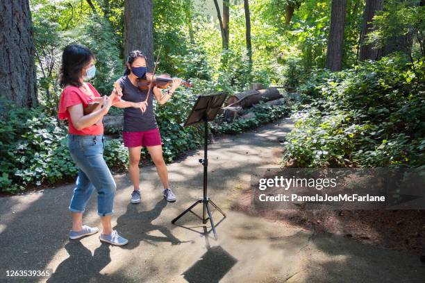 family reunion, asian sisters with face masks playing ukelele, violin - masked musicians stock pictures, royalty-free photos & images