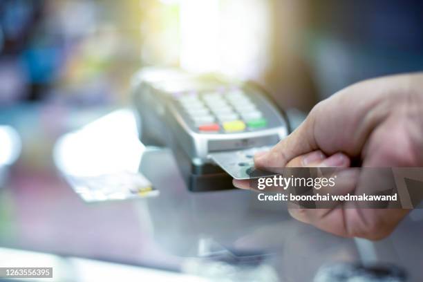 a finger press on credit card - card payment stock-fotos und bilder