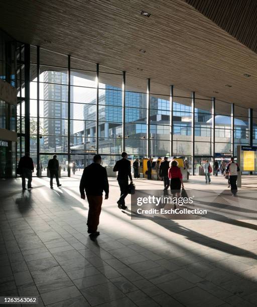 people on the move at rotterdam central station, the netherlands - rotterdam station stock pictures, royalty-free photos & images