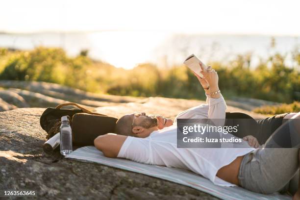 couple reading a book on a picnic - scandinavia picnic stock pictures, royalty-free photos & images