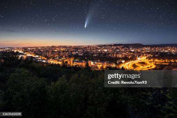 cometa neowise sobre la ciudad por la noche - comet fotografías e imágenes de stock