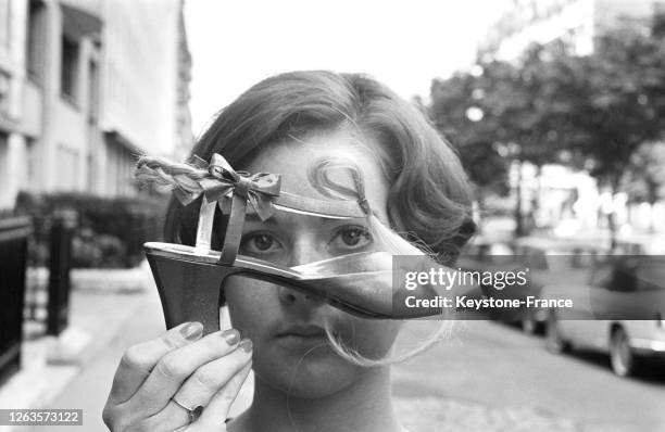 Une sandale noire garnie de mèches de cheveux, talon de 6 cm, création Dior, à Paris, France le 28 juillet 1966.