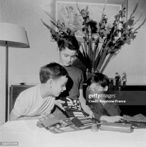 Trois écoliers devant leurs fournitures scolaires neuves, en France le 12 septembre 1966.