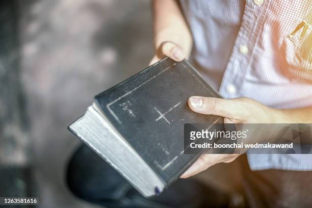 a man holding the holy bible. - pastor stock pictures, royalty-free photos & images