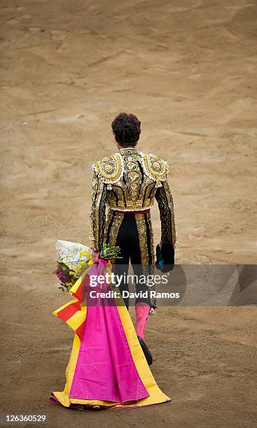 Bullfighter Jose Tomas holds a Catalan flag as he walks across the bullring after his performance during the last bullfight at the La Monumental on...