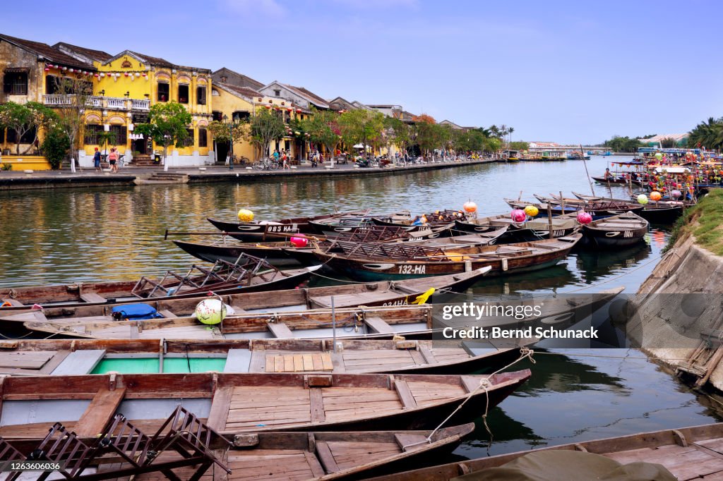 Thu Bon River with boats and the old town of Hoi An