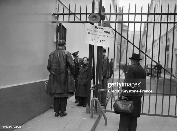 Un homme semble hésiter avant d'entrer à la Banque de France pour changer ses billets de 5000 francs, à Paris, France le 2 février 1948.