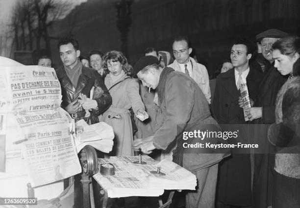 Près de la sortie du métro 'Opéra', il y a la queue pour acheter les éditions du soir, à Paris, France le 29 janvier 1948.