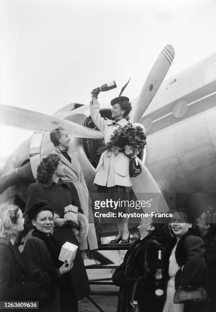 Actrice Renée Saint-Cyr, entourée de mannequins de la haute-couture, baptise l'avion 'Ciel de France' en brisant la traditionnelle bouteille de...